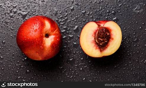 Nectarine fruit isolated on wet black background. Health concept. Nectarine fruit isolated on wet black background