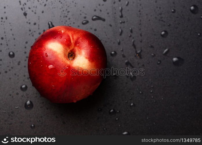 Nectarine fruit isolated on wet black background. Health concept. Copy space. Nectarine fruit isolated on wet black background