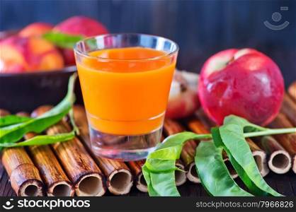 nectarine juice in glass and on a table