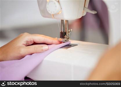 needlework and tailoring concept - sewing machine presser foot stitching fabric. sewing machine presser foot stitching fabric