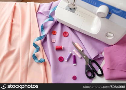 needlework, technology and tailoring concept - sewing machine with scissors, buttons, tape measure and fabric. sewing machine, scissors, buttons and fabric. sewing machine, scissors, buttons and fabric