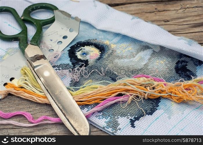 Needlework. Yarn and thread for embroidering on cloth by hand on a wooden surface.Tinted