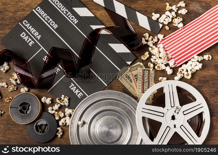 negatives stripes with clapperboard film reels tickets popcorn wooden desk. Beautiful photo. negatives stripes with clapperboard film reels tickets popcorn wooden desk