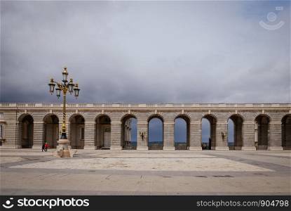 Neo-classical style of arches at the square of Plaza de la Armeria in rainy day. Madrid, Spain.