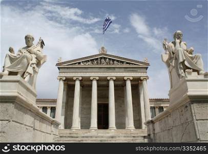 Neoclassical Academy of Athens in Greece showing main building and statues of ancient Greek philosopers Plato (left) and Socrates (right). The statues of goddess Pallas Athena and god Apollo are behind. The Academy of Athens is the highest research establishment in the country and one of the major landmarks of the city.