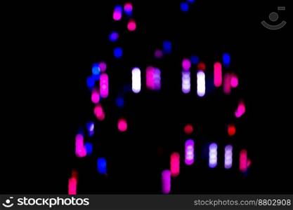 Neon colorful glow on a black backdrop. Iridescent neon background with light effect.. Futuristic neon light shapes on black defocused boke background.