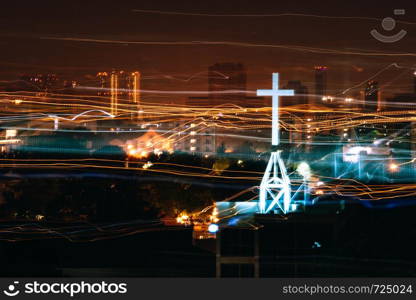 Neon light cross sign from church with light trail