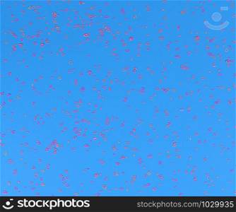 Neon pink sparkles in form of heart on blue background. Festive background for wallpaper, wrapping, backdrop, print or banner. Flat lay style.. Neon pink sparkles in form of heart on blue background. Festive background for wallpaper, wrapping, backdrop, print or banner.