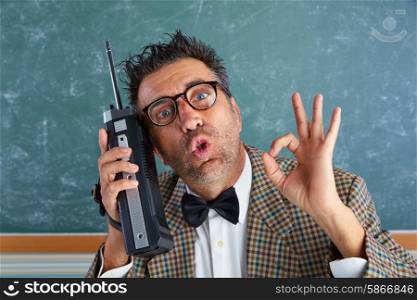 Nerd silly private investigator with retro walkie talkie on teacher balckboard