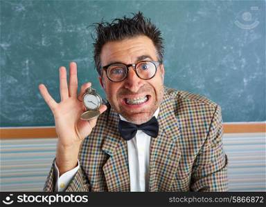 Nerd silly teacher showing vintage chain watch in green blackboard