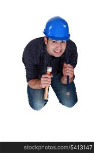 Nervous woodworker holding hammer and chisel