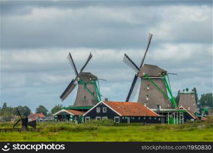 Netherlands. Cloudy day in the Zaanse Schans. Two old windmills and authentic Dutch houses. Two Old Windmills on a Cloudy Day