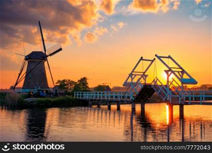 Netherlands rural landscape with windmills and bridge at famous tourist site Kinderdijk in Holland on sunset with dramatic sky. Windmills at Kinderdijk in Holland. Netherlands
