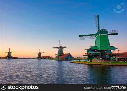 Netherlands rural lanscape - windmills at famous tourist site Zaanse Schans in Holland. Zaandam, Netherlands. Windmills at Zaanse Schans in Holland on sunset. Zaandam, Netherlands