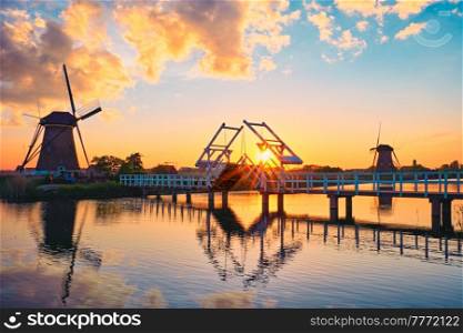 Netherlands rural lanscape with windmills and bridge at famous tourist site Kinderdijk in Holland on sunset with dramatic sky. Windmills at Kinderdijk in Holland. Netherlands