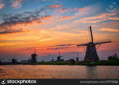 Netherlands rural lanscape with windmills at famous tourist site Kinderdijk in Holland on sunset with dramatic sky. Windmills at Kinderdijk in Holland. Netherlands