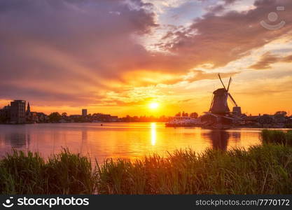 Netherlands rural scene - - windmills at famous tourist site Zaanse Schans in Holland on sunset with dramatic sky. Zaandam, Netherlands. Windmills at Zaanse Schans in Holland on sunset. Zaandam, Nether