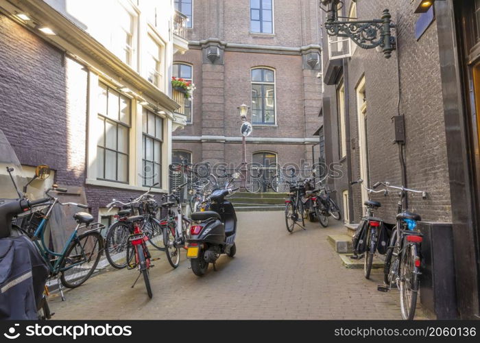 Netherlands. Sunny day in Amsterdam. Small Side Street With Bicycles and Scooters. Small Side Street of Amsterdam With Bicycles and Scooters