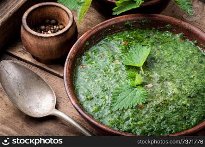 Nettle cream soup on wooden background.Soup with fresh nettles. Nettle leaf soup
