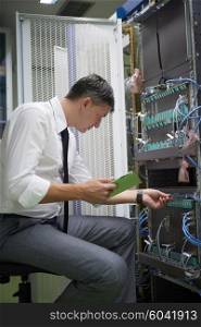 network engineer working in server room, corporate business man working on tablet computer