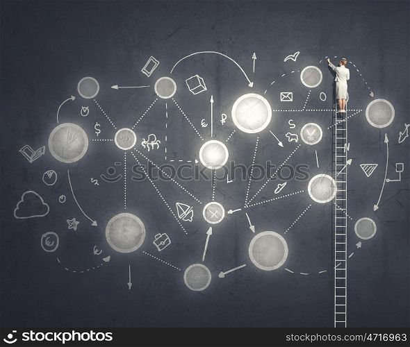 Networking business. Back view of businesswoman standing on ladder and drawing sketch on wall