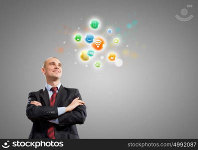 Networking concept. Young confident businessman and colorful media icons