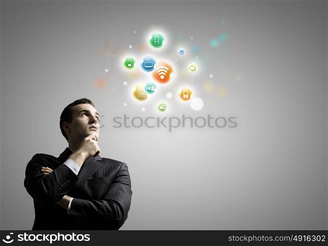 Networking concept. Young thoughtful businessman and colorful media icons