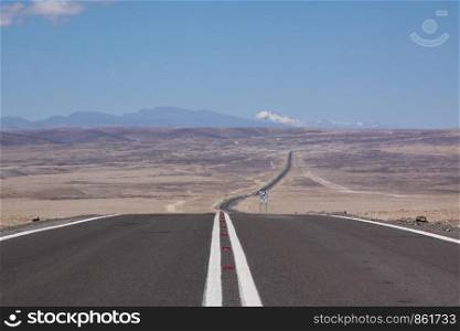 Never ending road leads straight through uncrowned lonely landscape