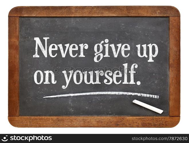Never give up on yourself - motivational advice on a vintage slate blackboard