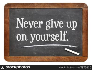 Never give up on yourself - motivational advice on a vintage slate blackboard