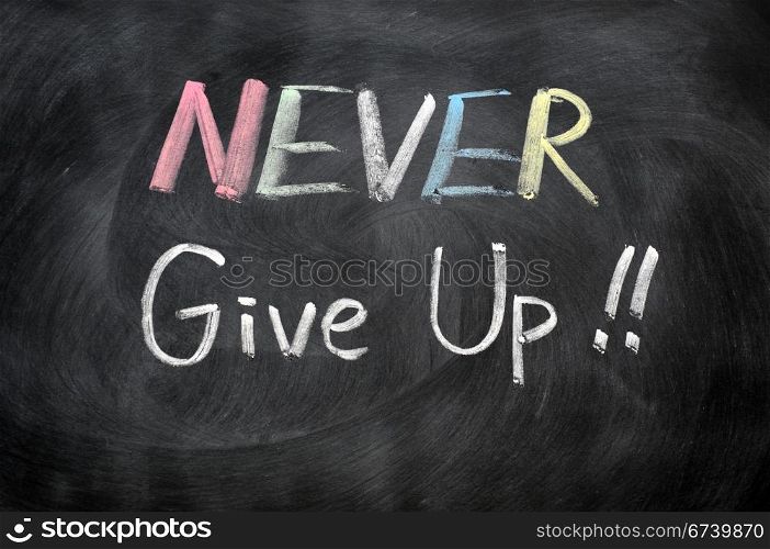 Never give up written in chalk on a blackboard