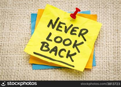 never look back reminder on a green sticky note against burlap canvas