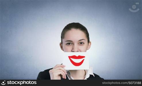 Never stop smiling. Pretty young girl holding white card with drawn smile