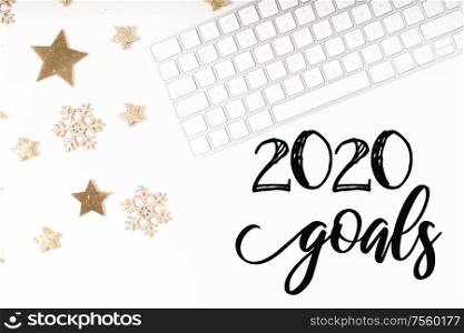 New 2020 year plan Christmas home office desk with keyboard and christmas gold decorations. Flat lay, top view. Christmas home office desk