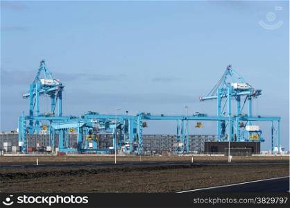 new blue industrial cranes for loading and unloading in the new harbor in holland called second maasvlakte