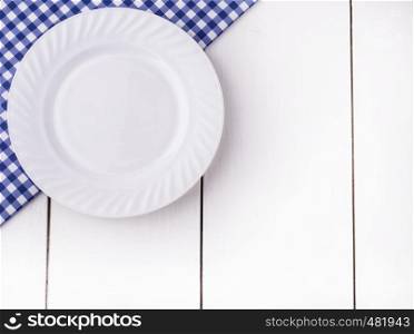 New Blue tablecloth on cage and empy plate on white wooden table background