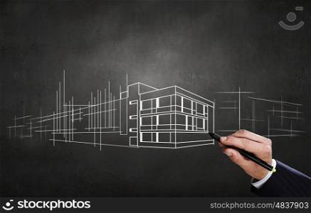 New construction development project. Close up of hand drawing construction project on chalkboard