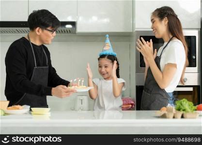 New generation asian family cook together and organize a small birthday party for our little daughter in the kitchen of the house