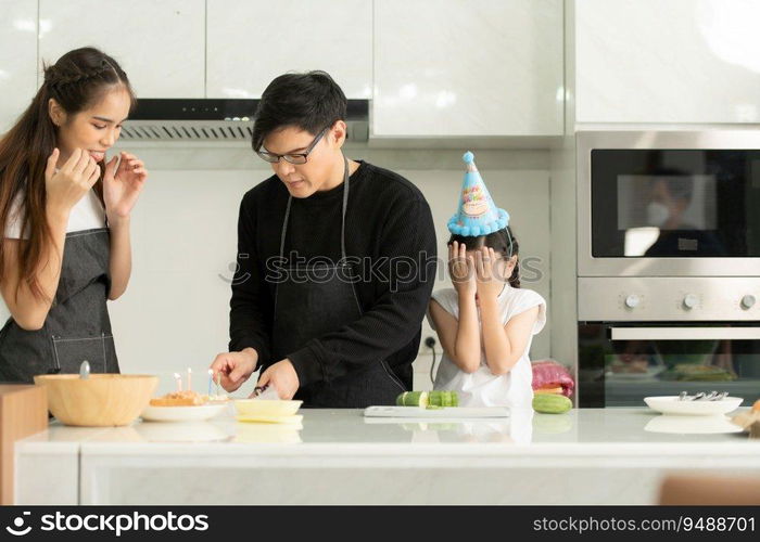 New generation asian family cook together and organize a small birthday party for our little daughter in the kitchen of the house