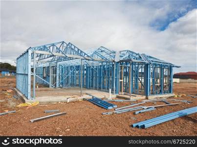 New home under construction using steel frames against cloudy sky