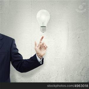 New idea. Businessman pointing at electric bulb with finger