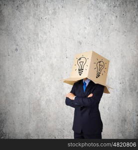 New idea. Businessman with box on head and idea symbol