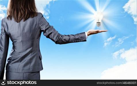 New idea. Close up of businesswoman hand with bulb in palm