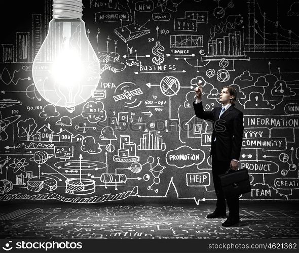 New idea. Young businessman and big light bulb against sketch background