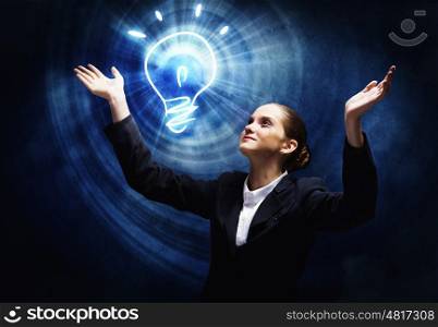 New idea. Young businesswoman praying on light bulb. Problem solution