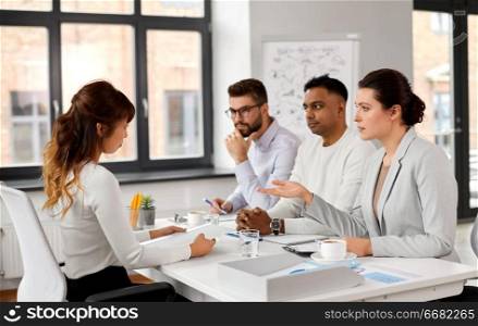 new job, hiring and employment concept - international team of recruiters having interview with asian female employee at office. recruiters having job interview with employee