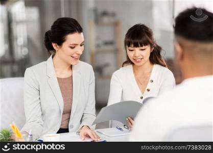 new job, hiring and employment concept - international team of recruiters having interview with male employee at office. recruiters having job interview with employee