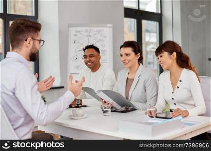 new job, hiring and employment concept - international team of recruiters having interview with male employee at office. recruiters having job interview with male employee