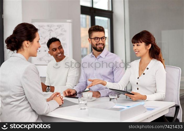 new job, hiring and employment concept - international team of recruiters having interview with female employee at office. recruiters having job interview with employee