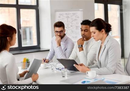 new job, hiring and employment concept - international team of recruiters looking at clipboard and having interview with asian female employee at office. recruiters having job interview with employee